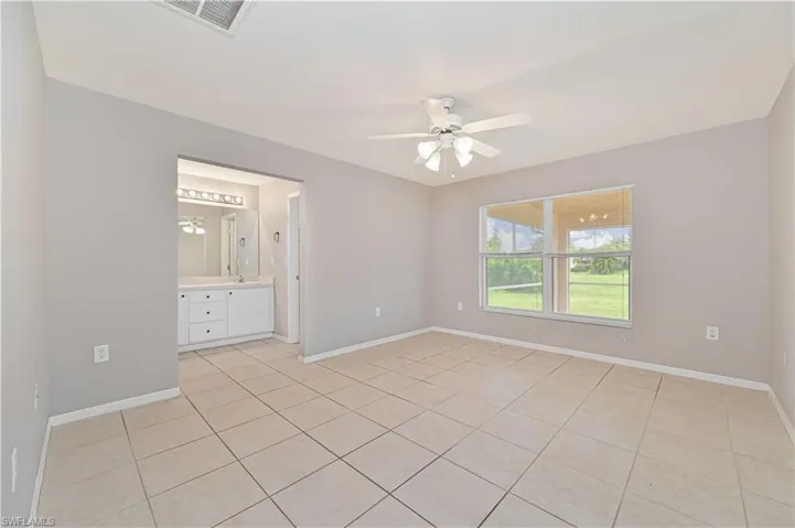 Spare room with a ceiling fan and light tile patterned flooring