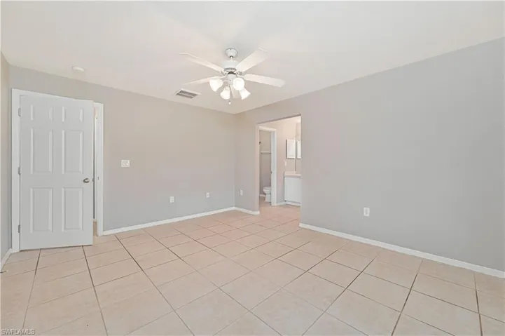 Spare room with ceiling fan and light tile patterned floors