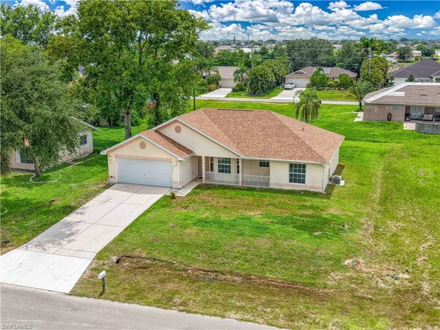 Ranch-style home with stucco siding, a garage, driveway, a porch, and a front lawn