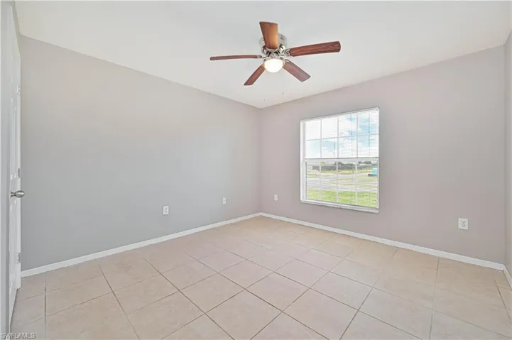 Unfurnished room featuring light tile patterned floors and a ceiling fan