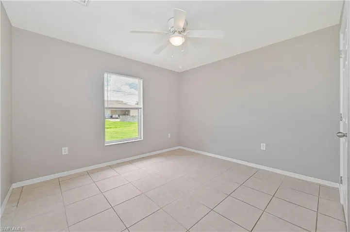 Unfurnished room with ceiling fan and light tile patterned floors