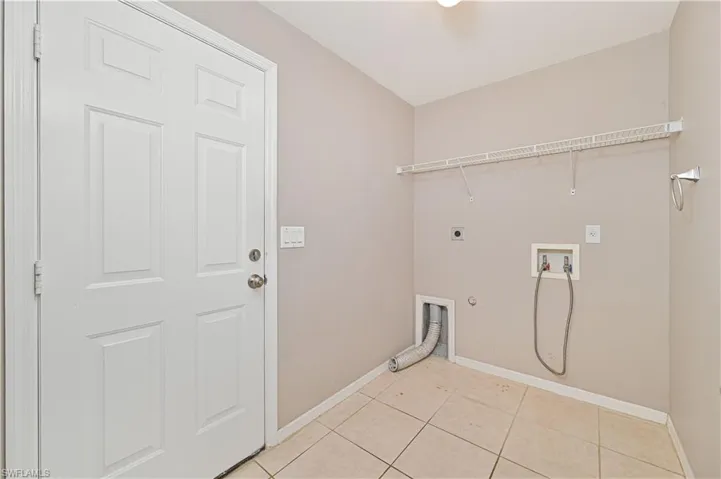 Laundry room with gas dryer hookup, electric dryer hookup, washer hookup, and light tile patterned flooring