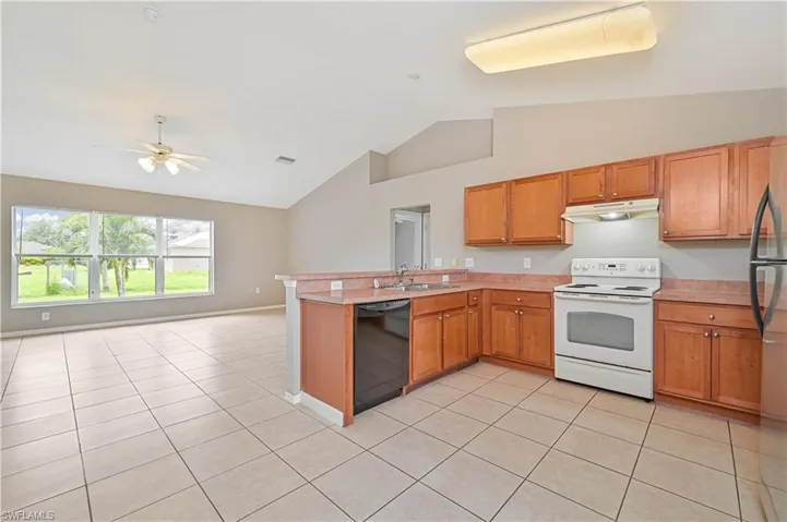 Kitchen with electric range, a peninsula, open floor plan, light countertops, and dishwasher