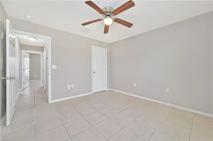 Unfurnished bedroom featuring light tile patterned floors and ceiling fan