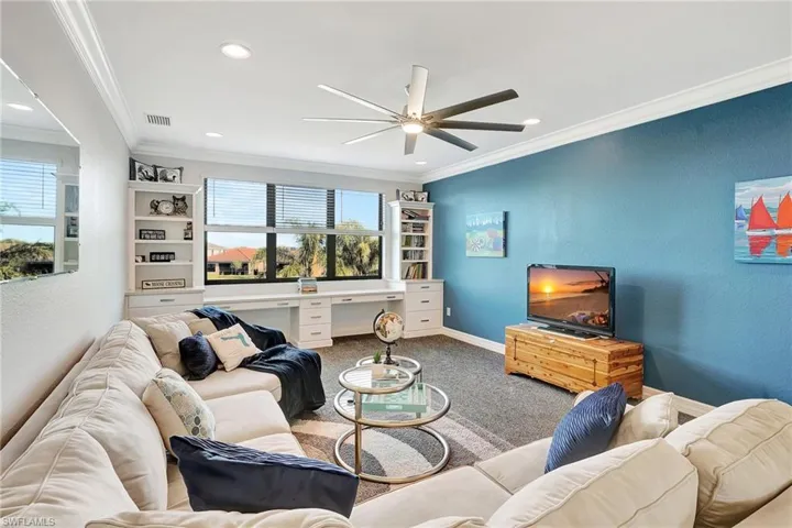Carpeted living room featuring a ceiling fan, ornamental molding, and recessed lighting