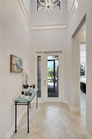 Foyer entrance featuring a high ceiling, tile patterned floors, and a chandelier