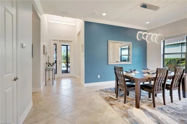 Dining space with plenty of natural light, ornamental molding, light tile patterned flooring, and recessed lighting