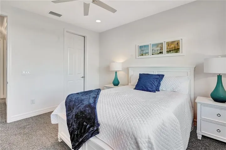 Carpeted bedroom with a ceiling fan and recessed lighting