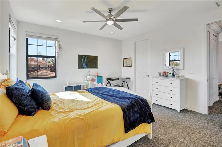 Carpeted bedroom with multiple windows, recessed lighting, ceiling fan, and a closet