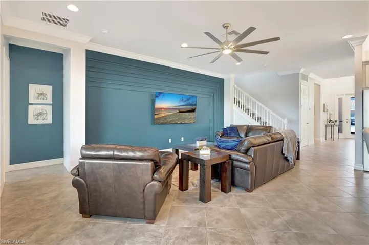Living room featuring crown molding, stairway, ceiling fan, recessed lighting, and light tile patterned floors