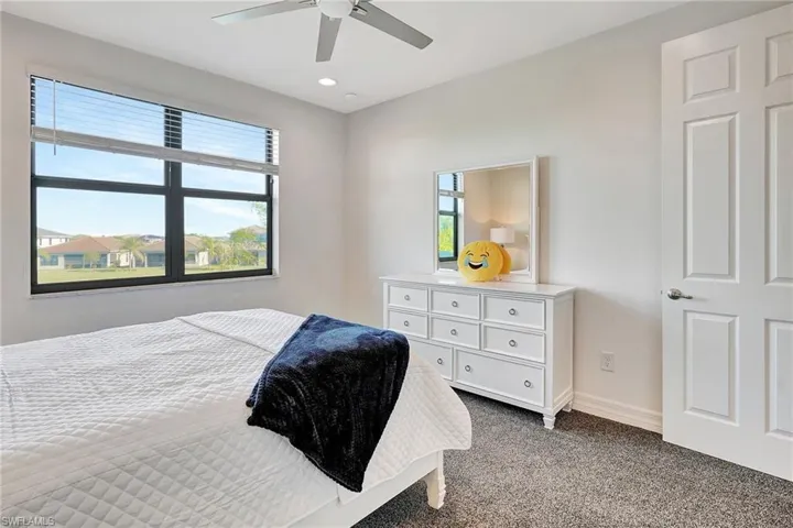 Bedroom with dark carpet, multiple windows, ceiling fan, and recessed lighting