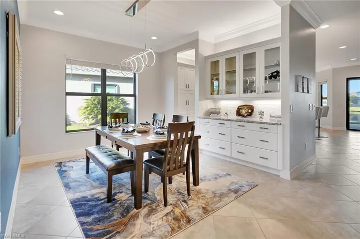 Dining space with crown molding, light tile patterned floors, and recessed lighting