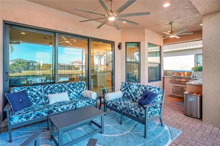 View of patio / terrace with a ceiling fan, an outdoor hangout area, exterior kitchen, and a water view