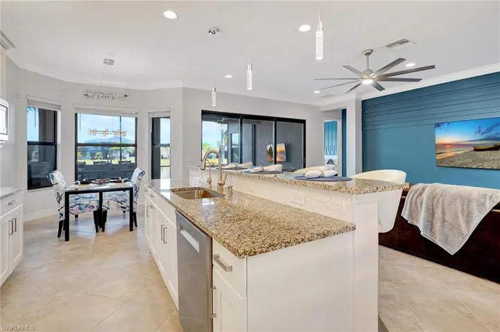 Kitchen featuring stainless steel dishwasher, open floor plan, recessed lighting, light tile patterned floors, and healthy amount of natural light