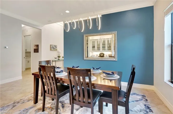 Dining room with ornamental molding and baseboards