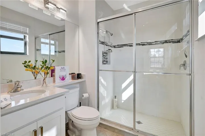 Bathroom with vanity, a stall shower, healthy amount of natural light, and tile patterned flooring