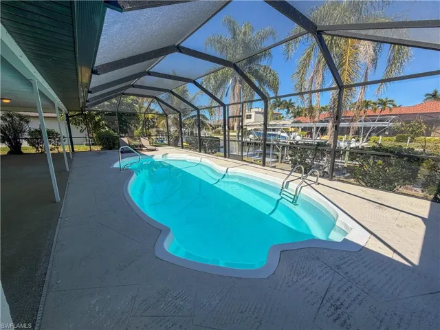 Outdoor pool with a lanai, a patio, and a sunroom