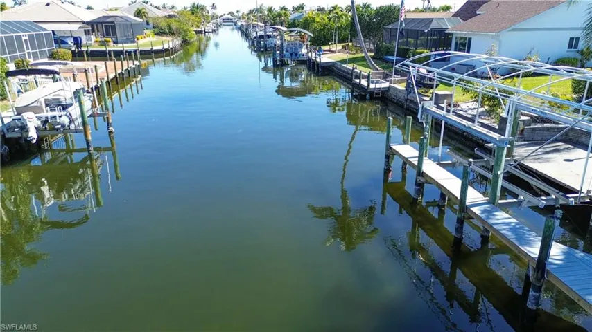 Dock featuring boat lift, a water view, and a residential view