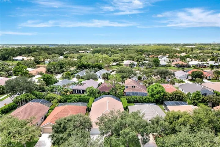 Aerial perspective showcasing residential properties with mature landscaping and clear skies