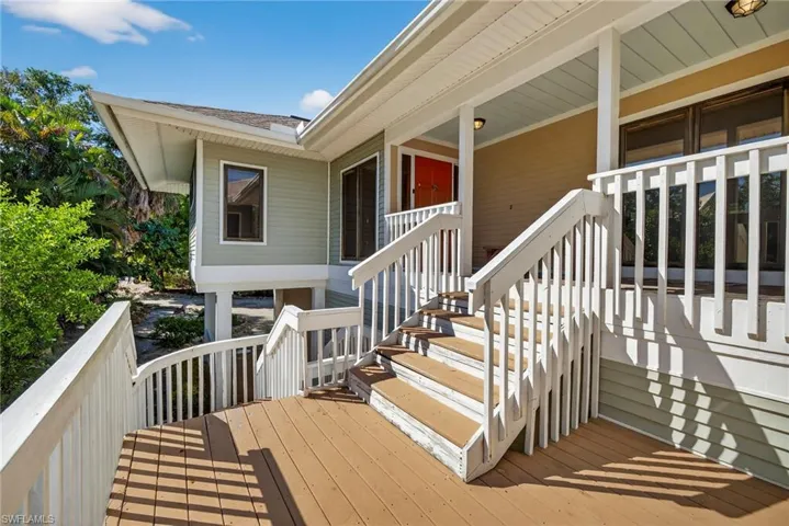 Classic southern elegance meets island living with open porch, grand staircase, and inviting charm.
