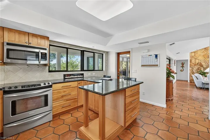 Spacious, light-filled kitchen, breakfast bar, stainless steel appliances and Mexican tile floors.