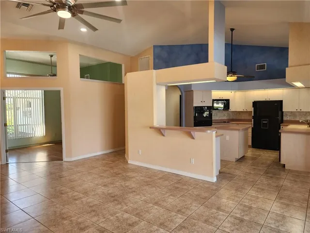 Kitchen with visible vents, a sink, black appliances, and a ceiling fan