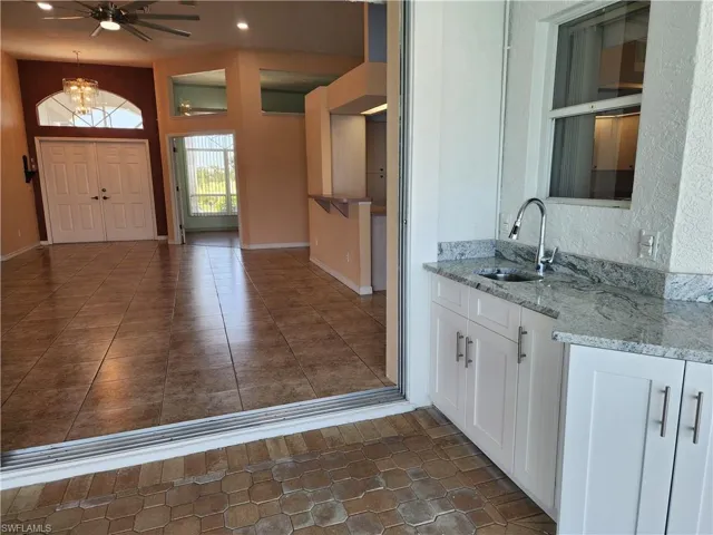 Kitchen with a sink, open shelves, white cabinets, and recessed lighting