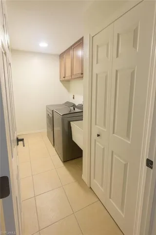 Laundry room with light tile patterned floors, cabinet space, independent washer and dryer, and recessed lighting