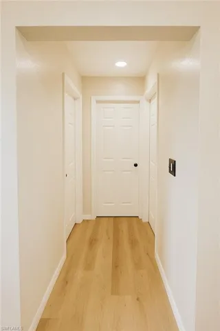 Corridor featuring light wood finished floors and recessed lighting