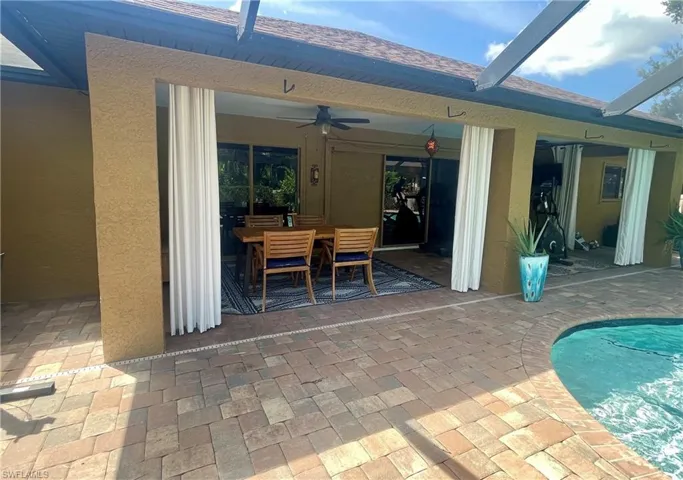View of patio / terrace featuring outdoor dining space, a ceiling fan, and an outdoor pool