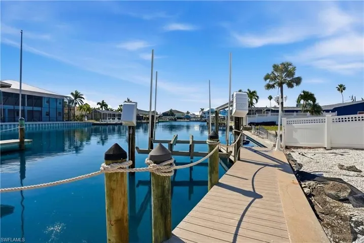 Private dock featuring a boat lift, sturdy pilings, and a rope railing - Virtually Edited Image
