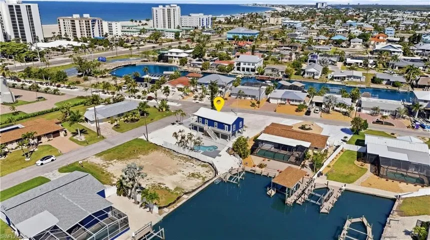 Waterfront property featuring a private boat dock, elevated structure, and a backyard pool - Virtually Edited Image