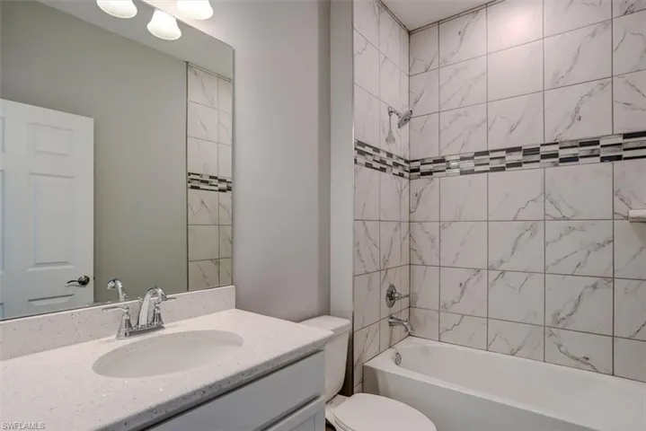 Full bathroom featuring vanity, toilet, and tiled shower / bath combo