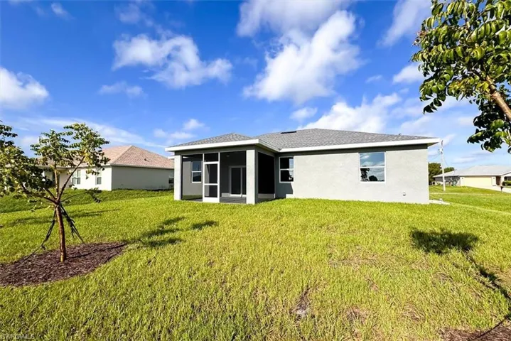 Rear view of house featuring a yard and a sunroom