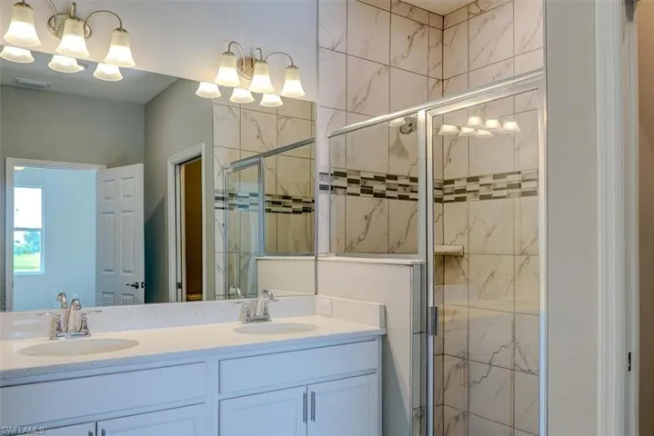 Bathroom featuring vanity and a shower with shower door