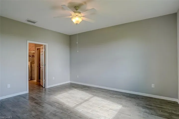 Primary bedroom room with ceiling fan and light wood-look tile floors