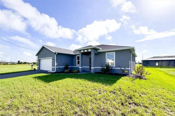 View of front facade with a front lawn and a garage