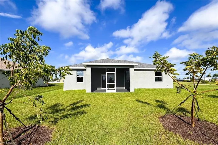 Rear view of property with a yard and a sunroom