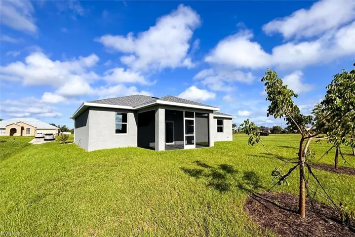 Rear view of house featuring a lawn