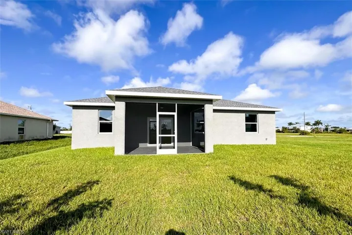 Back of house with a yard and a patio area
