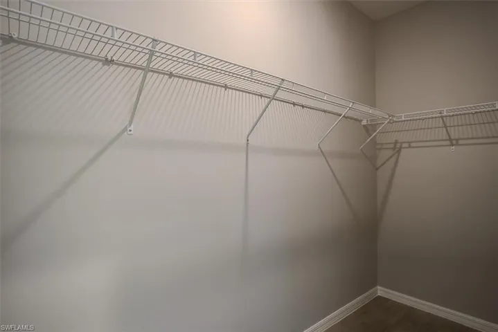 Walk in closet with wood-type flooring