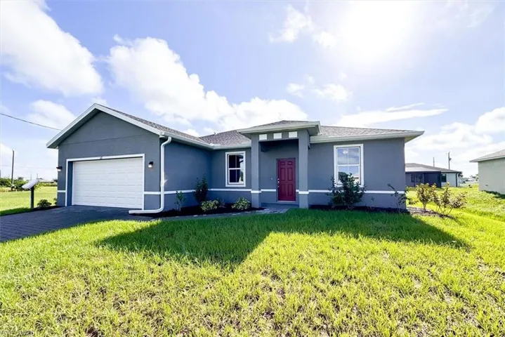 View of front of house with a garage and a front lawn