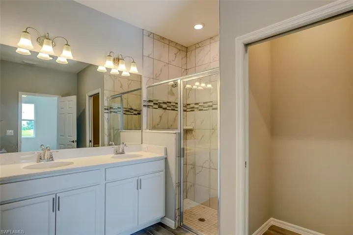 Bathroom featuring vanity and an enclosed shower