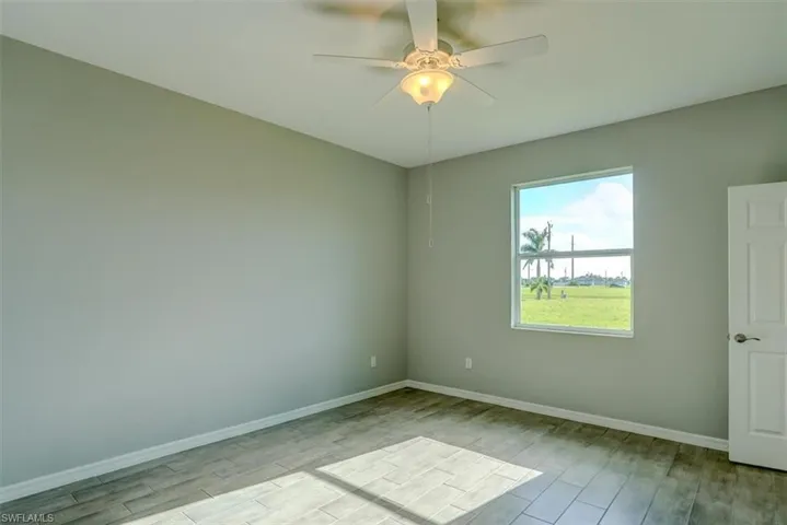 Empty room with ceiling fan and light hardwood / wood-style flooring