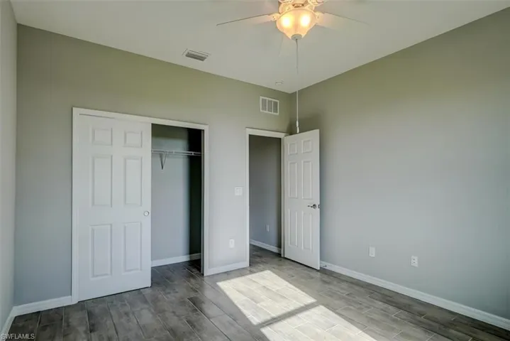 with ceiling fan and light wood-look style tile flooring
