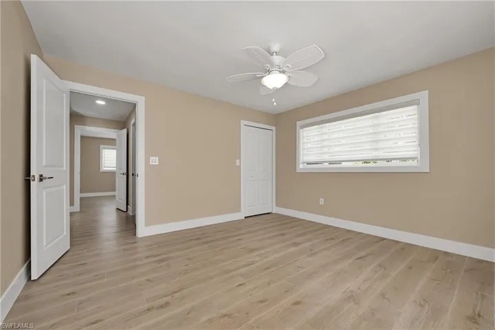 Unfurnished bedroom featuring light wood-style floors, a closet, and a ceiling fan