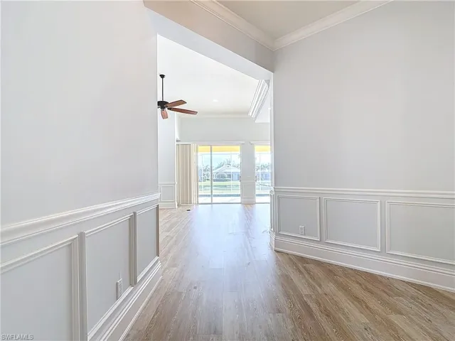 Hallway with crown molding and light hardwood / wood-style flooring