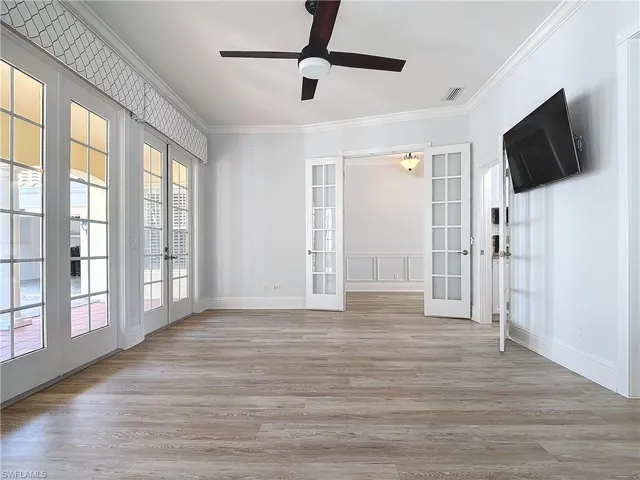 Empty room featuring french doors, ceiling fan, crown molding, and light hardwood / wood-style floors