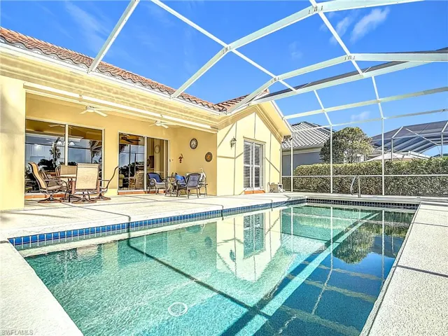 View of swimming pool with a lanai, ceiling fan, and a patio