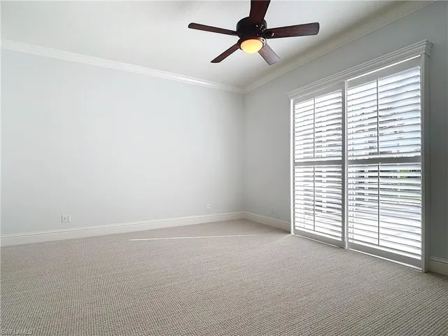 Carpeted empty room with ornamental molding and ceiling fan